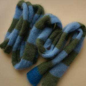 May include: A blue and green striped knitted scarf with a fluffy texture.