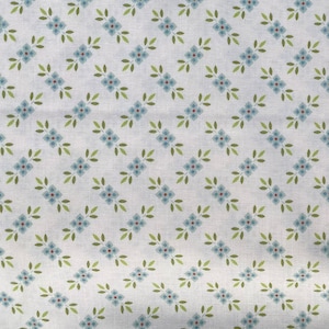 May include: A white fabric with a repeating pattern of blue flowers and green leaves. The pattern is arranged in a diamond shape.