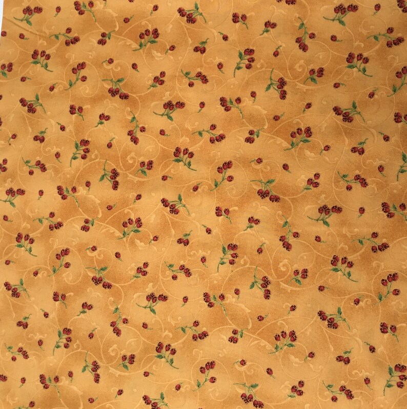 in stock and ready to ship! Red berries with green stems outlined in gold woven quilters cotton sold as yardage