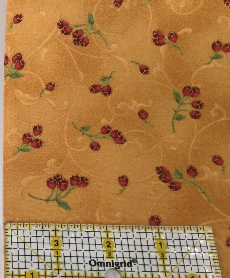 in stock and ready to ship! Red berries with green stems outlined in gold woven quilters cotton sold as yardage