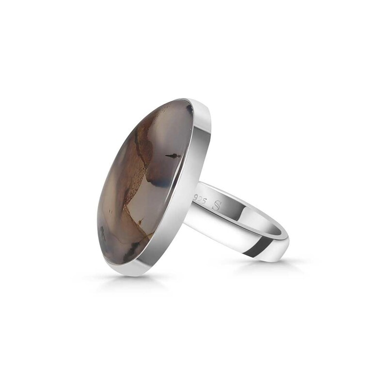 May include: A silver ring with a brown and white agate oval stone. The ring is marked with "925 S" on the band.