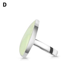 May include: A silver-toned ring featuring a smooth, pale green, teardrop-shaped stone set in a polished metal bezel. The letter D is visible in the upper left corner. The ring is shown from a side profile angle, highlighting the band and setting.