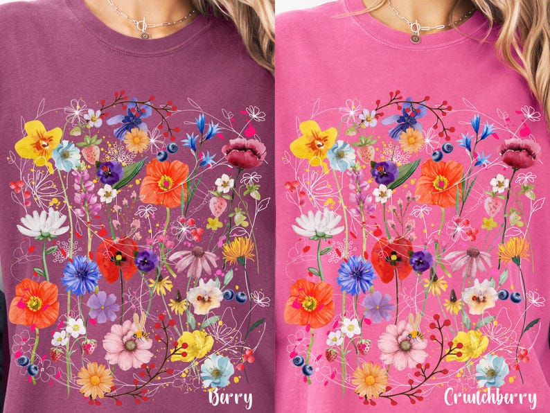 May include: Two pink and purple t-shirts with a floral design. The design features a variety of flowers in shades of pink, red, yellow, blue, and green. The text "Barry" is printed on the left shirt and "Crunchberry" is printed on the right shirt.