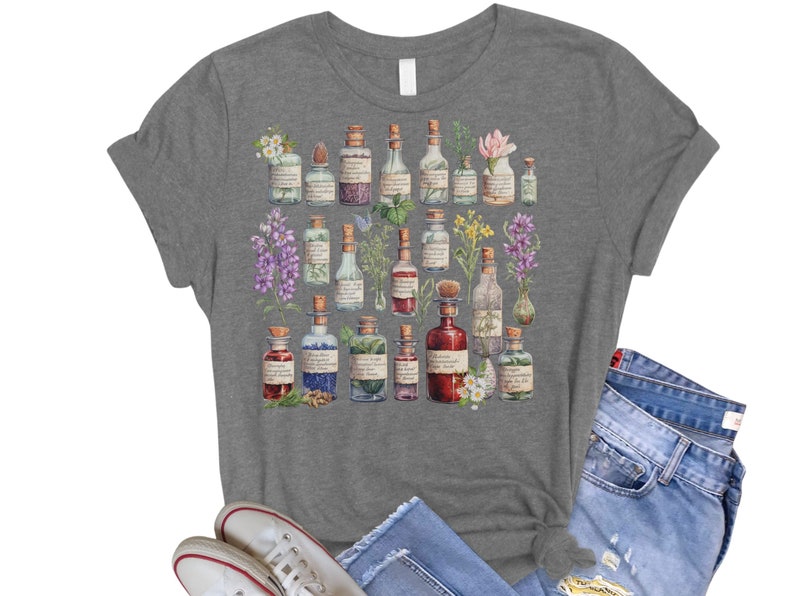 May include: A heather gray t-shirt with a vintage illustration of various glass bottles filled with colorful liquids and surrounded by flowers and herbs.