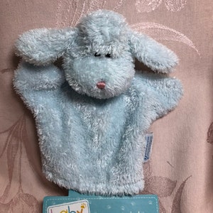 May include: A light blue plush hand puppet shaped like a dog with a pink nose. The puppet is labeled "baby BOYDS Safe in Baby's Arms... Designed by the Moms at Boyds".