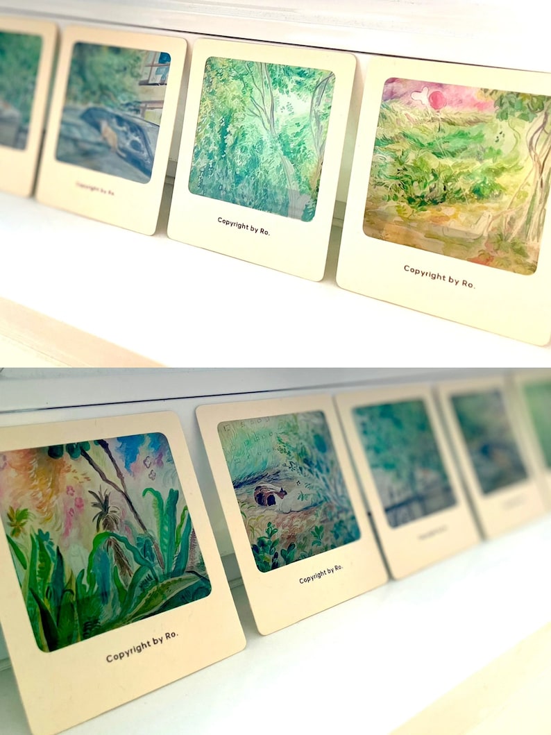 May include: A collection of six framed watercolor paintings, each featuring a different nature scene. The paintings are displayed on a white shelf. The paintings are all signed "Copyright by Ro."
