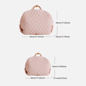 K&ouml;nnte beinhalten: Zwei rosafarbene, gesteppte Reisetaschen mit braunen Ledergriffen. Die gr&ouml;&szlig;ere Tasche misst 45 cm in der Breite, 44 cm in der H&ouml;he und 34 cm in der Tiefe. Die kleinere Tasche misst 44 cm in der Breite, 33 cm in der H&ouml;he und 21 cm in der Tiefe.
