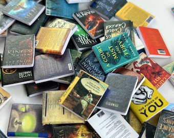 May include: A large pile of miniature books with various titles and authors. The books are arranged in a random order and some are stacked on top of each other. The books are all different colors and sizes.