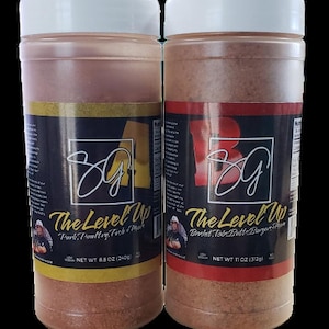 May include: Two clear plastic jars with white lids containing brown spice blends. The jars have black labels with white text that reads "The Level Up" and "NET WT 8.5 OZ (240g)" and "NET WT 11 OZ (312g)". The left jar has a yellow background and the text "Pork, Poultry, Fish & More". The right jar has a red background and the text "Brisket, Ribs, Butt & Burger & More".