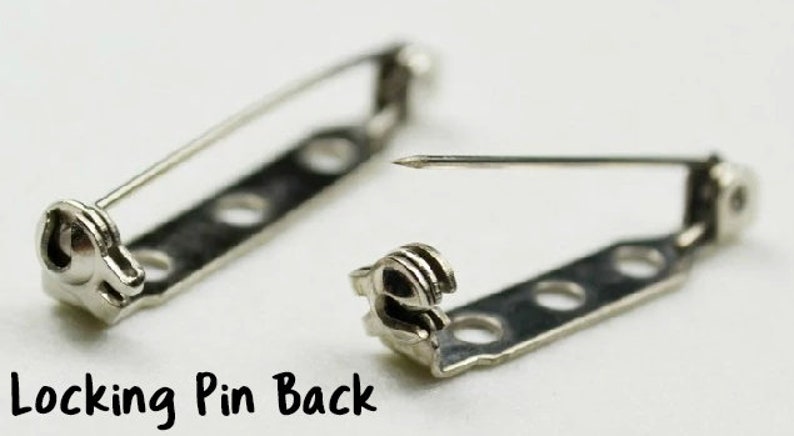 May include: Two silver locking pin backs for jewelry making. Each pin back has a locking mechanism and a straight pin. The pin backs are designed to be attached to the back of brooches, pins, or other jewelry.