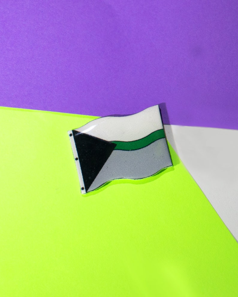 May include: A green, white, and black flag with a wavy design. The flag is on a green and purple background.