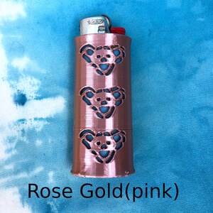 May include: Rose gold lighter case with three cut-out bear designs.