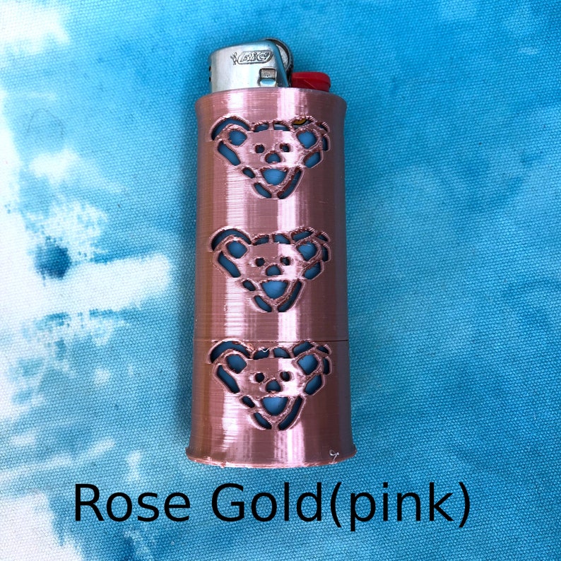 May include: Rose gold lighter case with three cut-out bear designs.