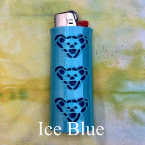 May include: A light blue lighter with three cut-out bear faces. The lighter is labeled "Ice Blue".