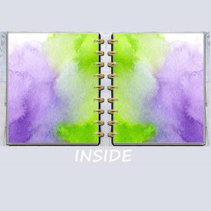 May include: Open notebook with watercolor-style pages. The left page features a purple and blue watercolor wash, while the right page has a green and yellow wash. The word "INSIDE" is printed in white.