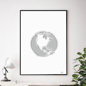 May include: A black framed print of a line drawing of the Earth with North America centered. The drawing is in shades of gray on a white background.
