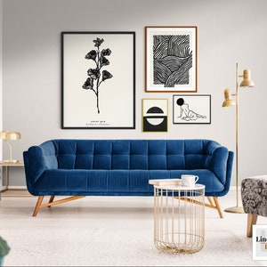 May include: A blue velvet sofa with a gold metal side table and three black and white framed prints on the wall. The prints feature a floral design, abstract lines, and a figure.