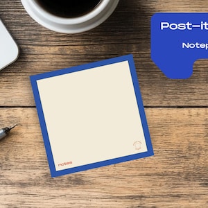 Può includere: Un blocco note Post-it con bordo blu e interno color crema è appoggiato su una scrivania di legno. Il blocco note ha la parola "notes" in rosso in basso a sinistra. Una penna, una tazza di caffè e un laptop sono anche sulla scrivania.