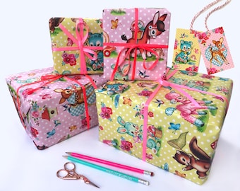 May include: Four gift boxes wrapped in pink and yellow paper with a polka dot pattern. The boxes are decorated with pink ribbon and feature illustrations of animals, including a deer, a bunny, a lamb, and a squirrel. The boxes are arranged in a pyramid shape, with the largest box at the bottom and the smallest box at the top. Two gift tags with animal illustrations are also visible in the image.