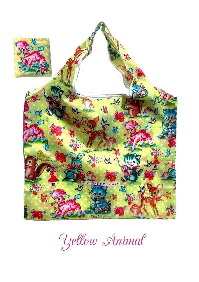 Puede incluir: Un bolso tote amarillo y una bolsa a juego con un estampado de animales, flores y mariposas de estilo vintage. El dise&ntilde;o incluye ciervos, corderos, gatos y osos. Tambi&eacute;n se ven las palabras "my happy place".