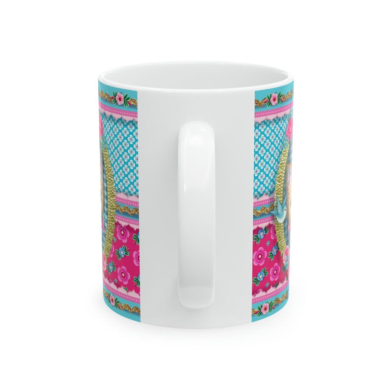 May include: White ceramic mug with a colorful patchwork design featuring pink, blue, and gold accents. The design includes floral patterns and geometric shapes.