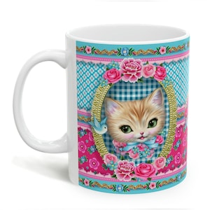 May include: White ceramic mug with a colorful design featuring a kitten with blue eyes, a blue bird, and pink and blue flowers. The background is a blue and white checkered pattern.