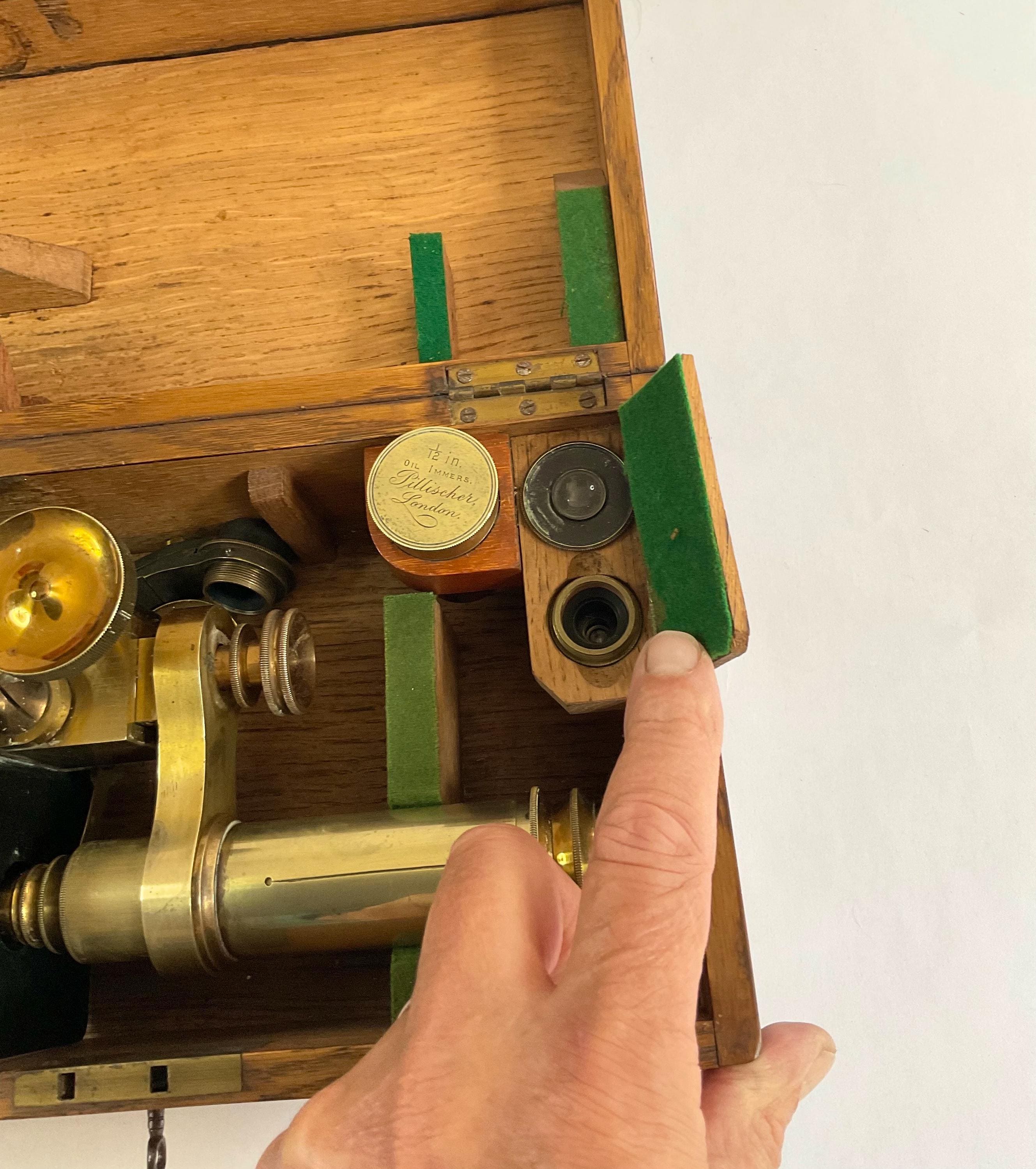 オーク材のケースと付属品が付いたアンティーク顕微鏡。医学科学の