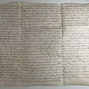 May include: An antique off-white parchment document featuring dense, handwritten cursive text in dark brown ink. The paper shows visible horizontal and vertical fold lines, creating a grid-like texture across the surface of the historical legal record.