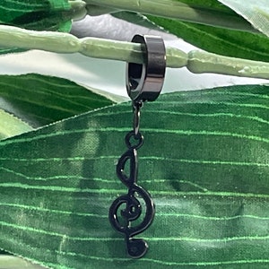 May include: Black metal earring with a treble clef charm. The earring is a hoop with a black finish.