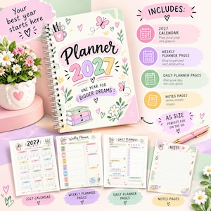 Op de afbeelding: Een spiraalgebonden planner voor 2027 met een crèmekleurige kaft voorzien van kleurrijke illustraties van bloemen, vlinders en boeken. De tekst luidt Planner 2027 One Year for Bigger Dreams. Bevat een kalender, week- en dagpagina's en notitiepagina's.