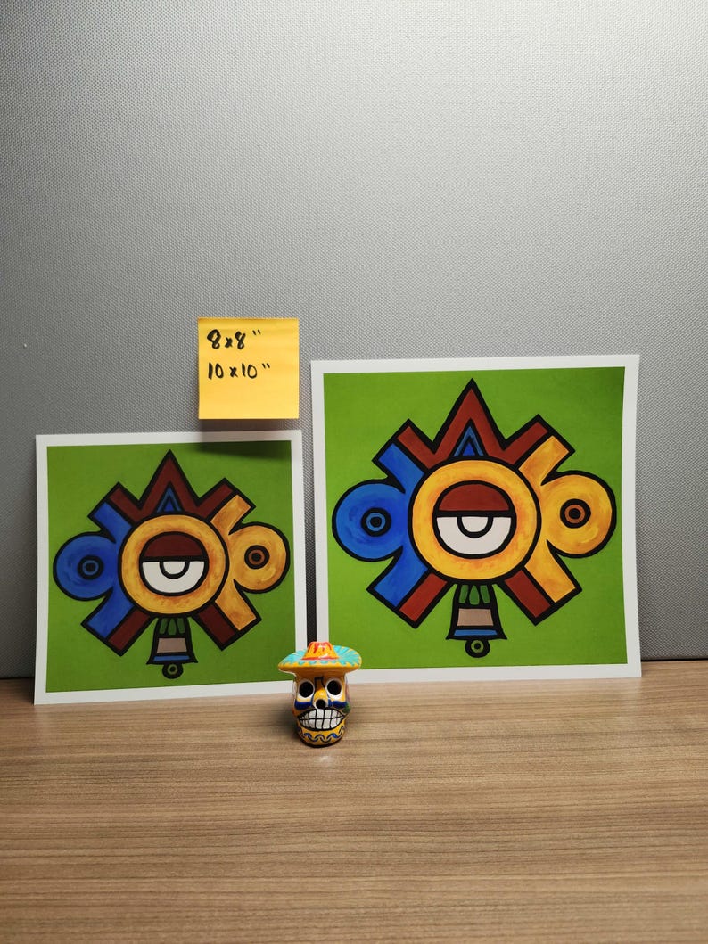 May include: Two colorful prints of a stylized geometric design with a red, yellow, blue, and green color scheme. The prints are on white paper with a green border. The smaller print is 8x8 inches and the larger print is 10x10 inches. A small, colorful, ceramic skull with a hat is in the foreground.