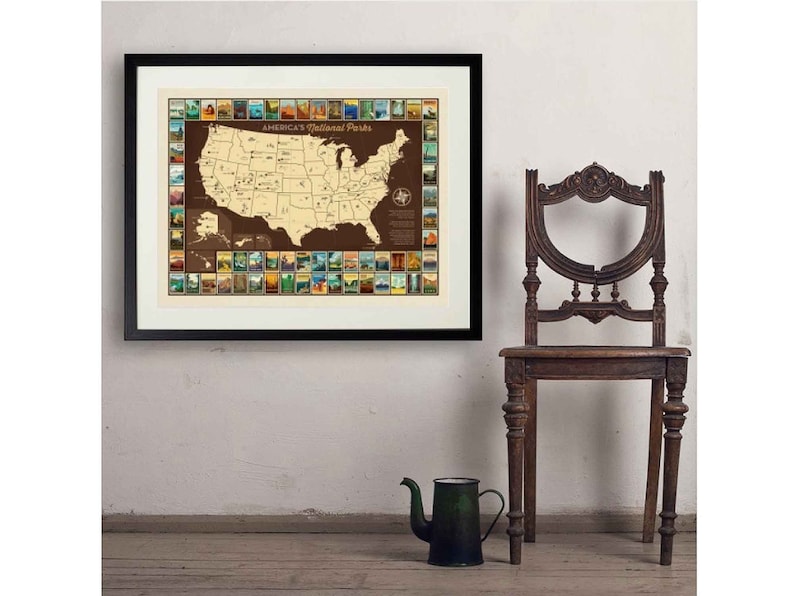 May include: A framed map of the United States with a brown background and a gold border. The map shows the locations of all 63 national parks in the United States. Each park is represented by a small, colourful illustration. The map is titled "America's National Parks".