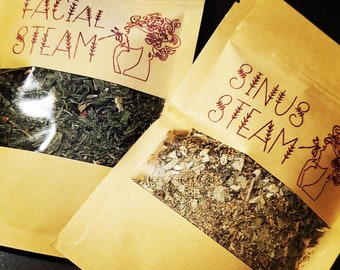 May include: Two brown paper bags with clear plastic windows. The bags contain dried herbs and have the text "Facial Steam" and "Sinus Steam" printed on them.