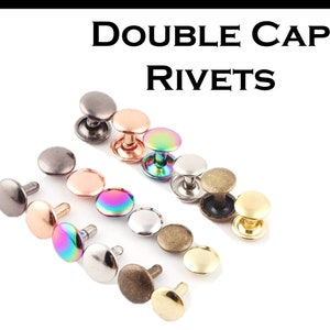 May include: Assortment of double cap rivets in various colors, including silver, gold, bronze, rose gold, and iridescent.  The rivets are arranged in a row on a white background.  DOUBLE CAP RIVETS is written in black text at the top of the image.