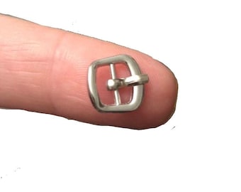 Op de afbeelding: Een zilveren metalen gesp voor een band of riem.