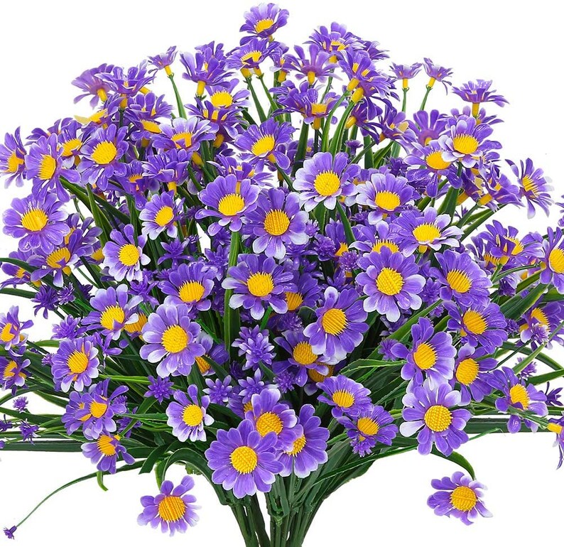 Pode incluir: Um buqu&ecirc; de margaridas artificiais roxas com centros amarelos. As flores est&atilde;o dispostas em um cacho e t&ecirc;m uma apar&ecirc;ncia realista.