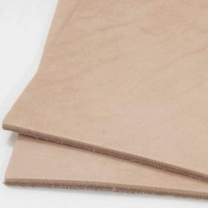 May include: Two pieces of light brown leather, stacked on top of each other.