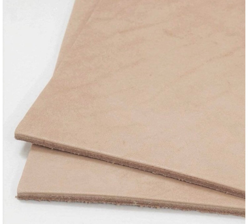 May include: Two pieces of light brown leather, stacked on top of each other.