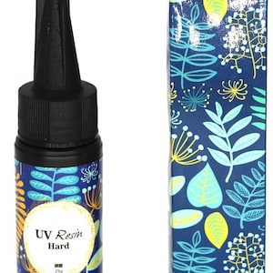 May include: A small bottle of UV resin with a black cap and a blue and green floral pattern. The bottle label reads "UV Resin Hard" and "25g".