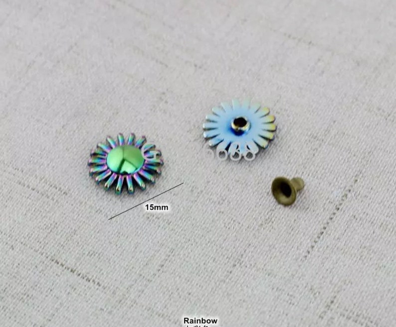 May include: Two iridescent rainbow colored metal flower-shaped buttons with a 15mm diameter. The buttons have a raised center and a flat back. A small metal stud is also included.