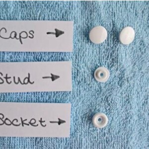 May include: Three white plastic buttons labeled "Caps", "Stud", and "Socket" with arrows pointing to the right.