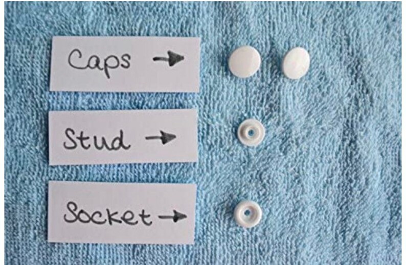 May include: Three white plastic buttons labeled "Caps", "Stud", and "Socket" with arrows pointing to the right.