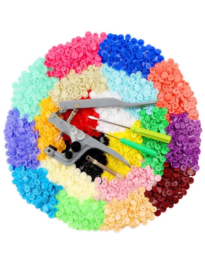 May include: A set of colorful plastic snap buttons in various colors, including red, blue, green, yellow, and white. The set also includes a tool for attaching the buttons to fabric.