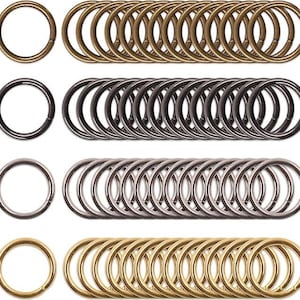 May include: A set of 40 metal key rings in three different finishes: gold, silver, and black. The key rings are all the same size and shape, and they are arranged in four rows of ten.