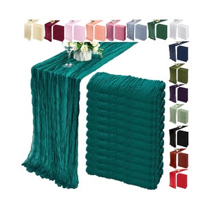 Può includere: Viene mostrato un runner da tavolo in tessuto stropicciato color verde acqua, drappeggiato su un tavolo con un calice e dei fiori. Accanto c'è una pila di runner abbinati. Vengono mostrati runner aggiuntivi in vari colori.