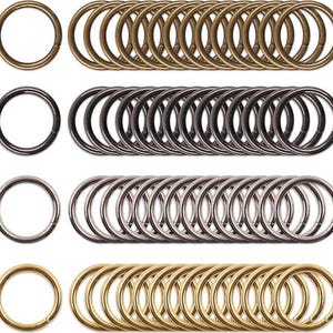 May include: A set of 40 metal key rings in four different finishes: gold, silver, black, and antique brass. The rings are arranged in four rows of ten rings each.