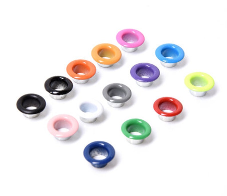May include: Assortment of colorful metal eyelets in various colors, including black, white, red, green, blue, orange, yellow, pink, and purple.