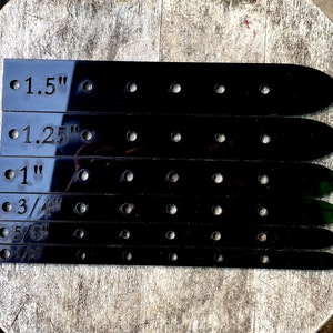 May include: Six black leather belt straps with different size markings: 1.5", 1.25", 1", 3/4", 5/8", and 1/2".