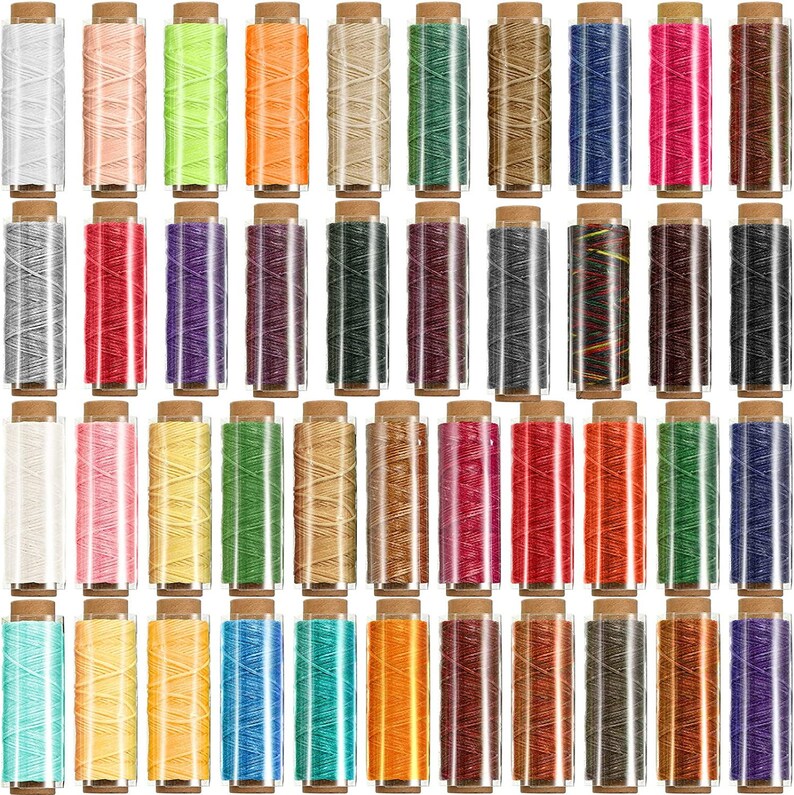 May include: A set of 48 spools of waxed thread in various colors, including white, pink, yellow, green, orange, brown, blue, red, purple, black, and gray. The spools are arranged in rows and are all in clear plastic containers with brown tops.