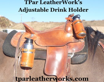 Op de afbeelding: Een bruin leren zadel met twee bruine leren drinkhouders aan de zijkant. De houders zijn verstelbaar en passen op verschillende flessenformaten. Het zadel zit op een bruin paard. De tekst "TPar LeatherWork's Adjustable Drink Holder" staat bovenaan de afbeelding. De tekst "tparleatherworks.com" staat onderaan de afbeelding.